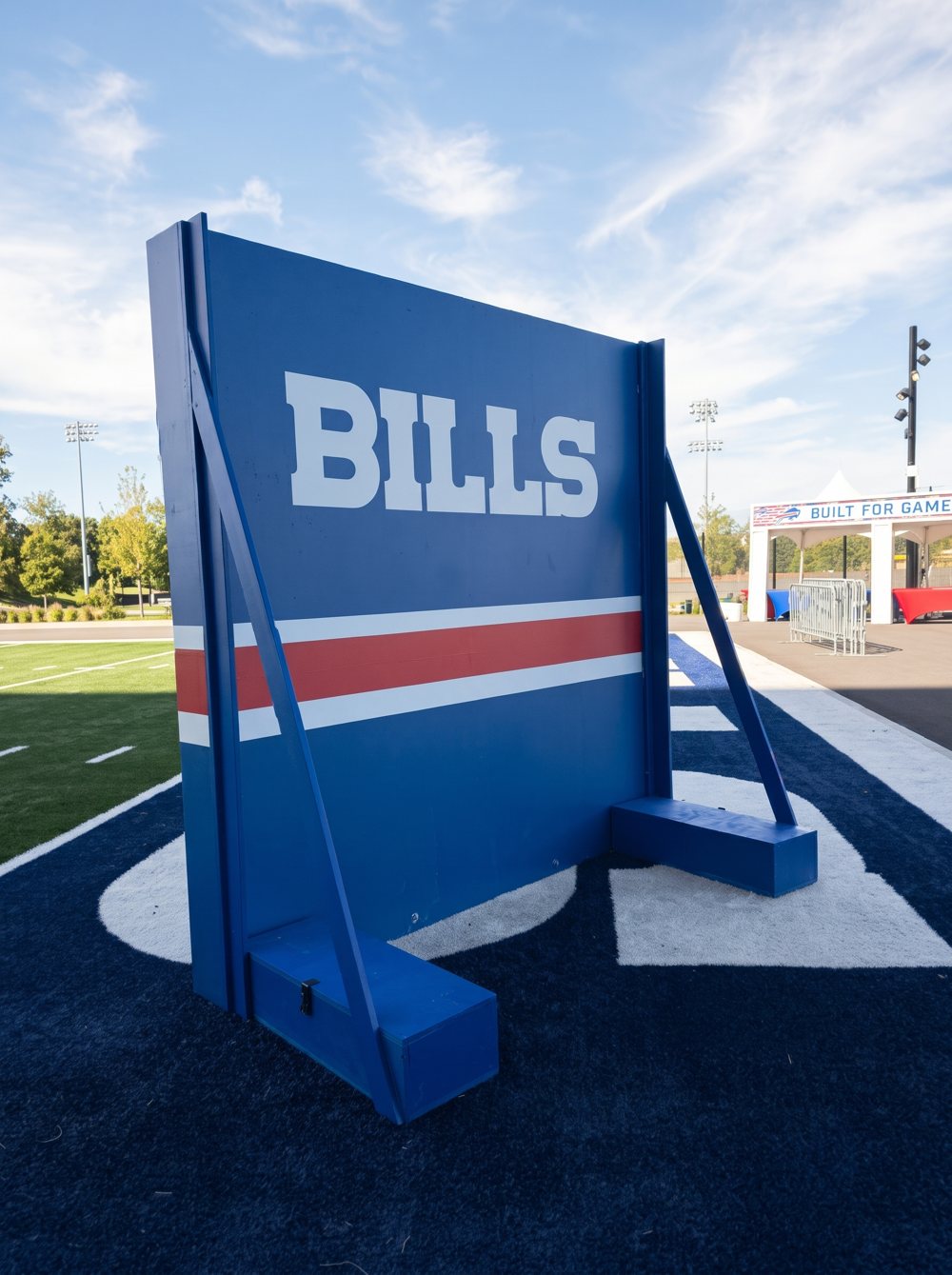 A blue Buffalo Bills display wall with a red and white stripe, standing on the turf at a Bills fan event
