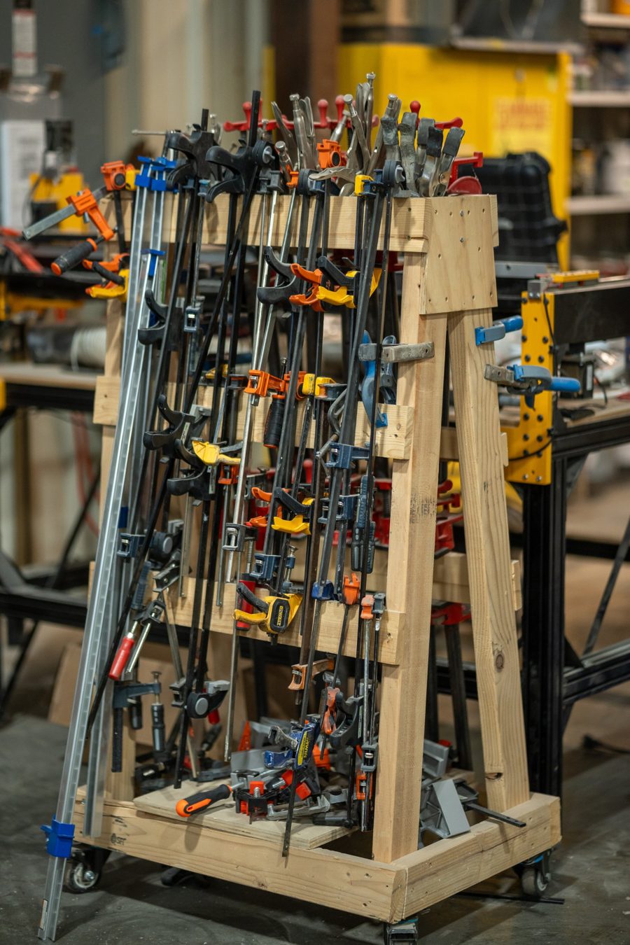 A homemade wooden cart packed with bar clamps, spring clamps and locking pliers