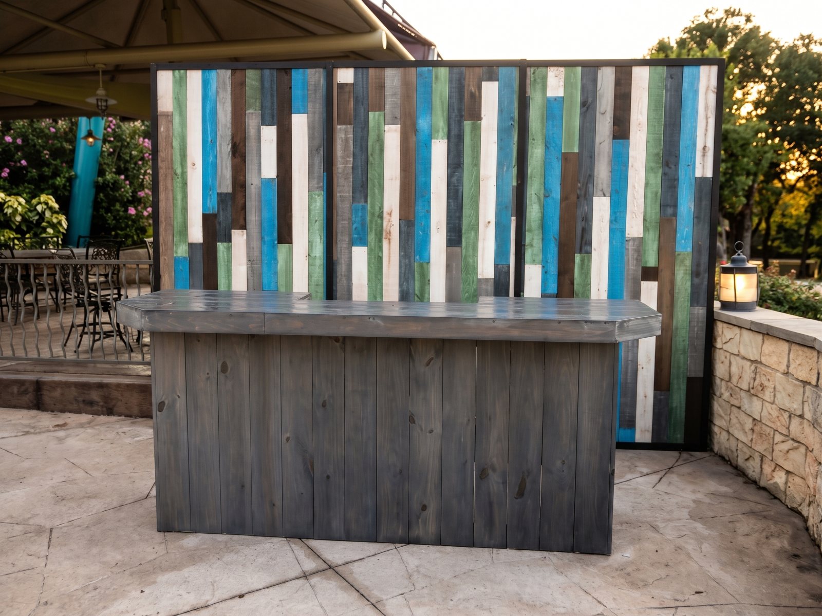 A rustic bar with a multicolor painted-plank backdrop on an outdoor patio