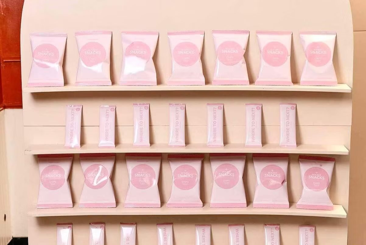 Rows of pink treat bags displayed on white wall shelves