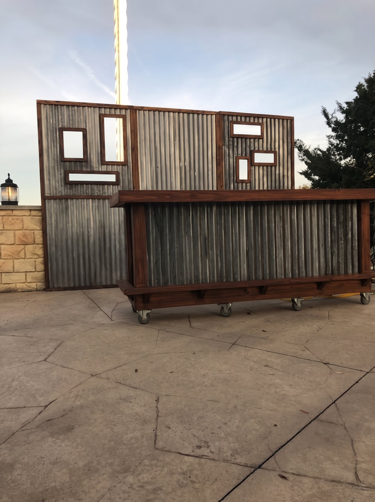 A rustic bar with corrugated metal and wood paneling on casters