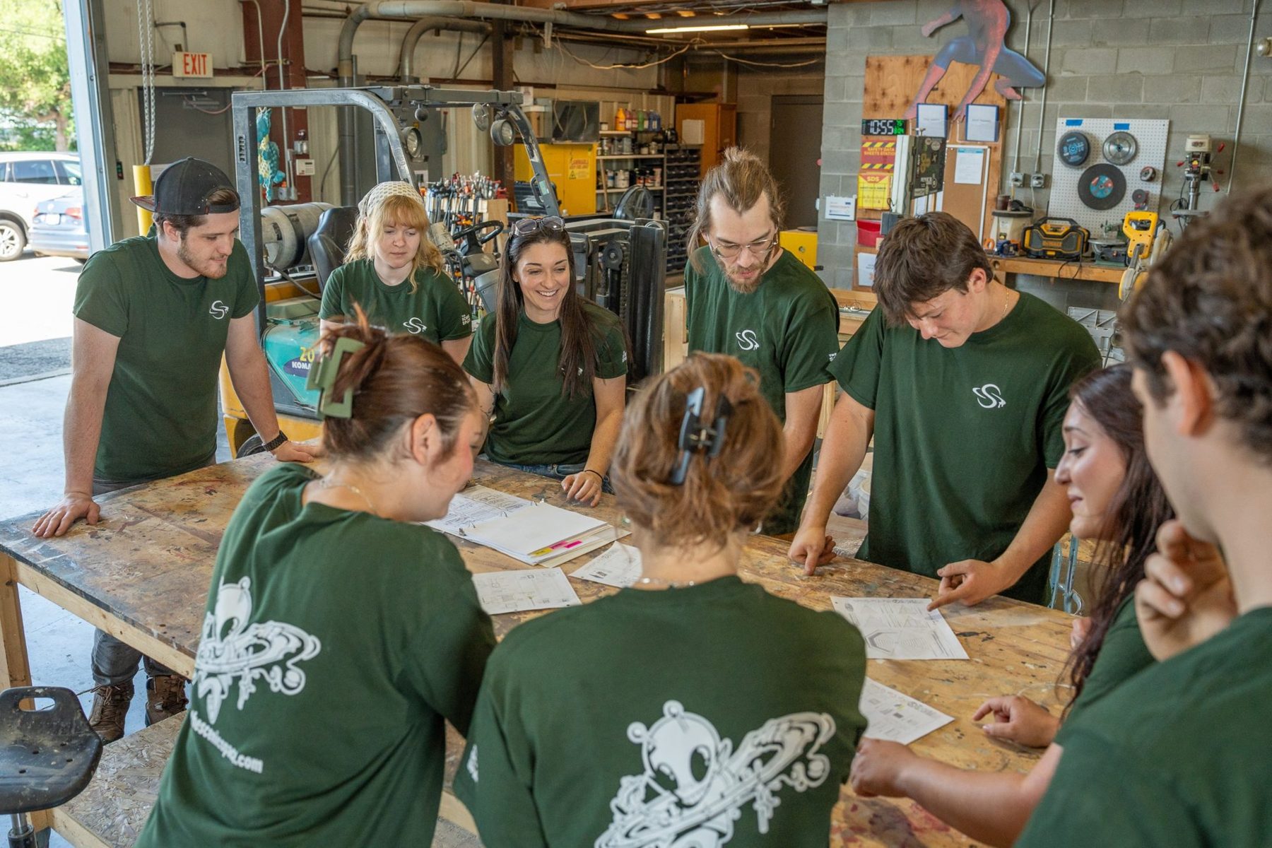 The crew gathered around a workbench reviewing shop drawings together