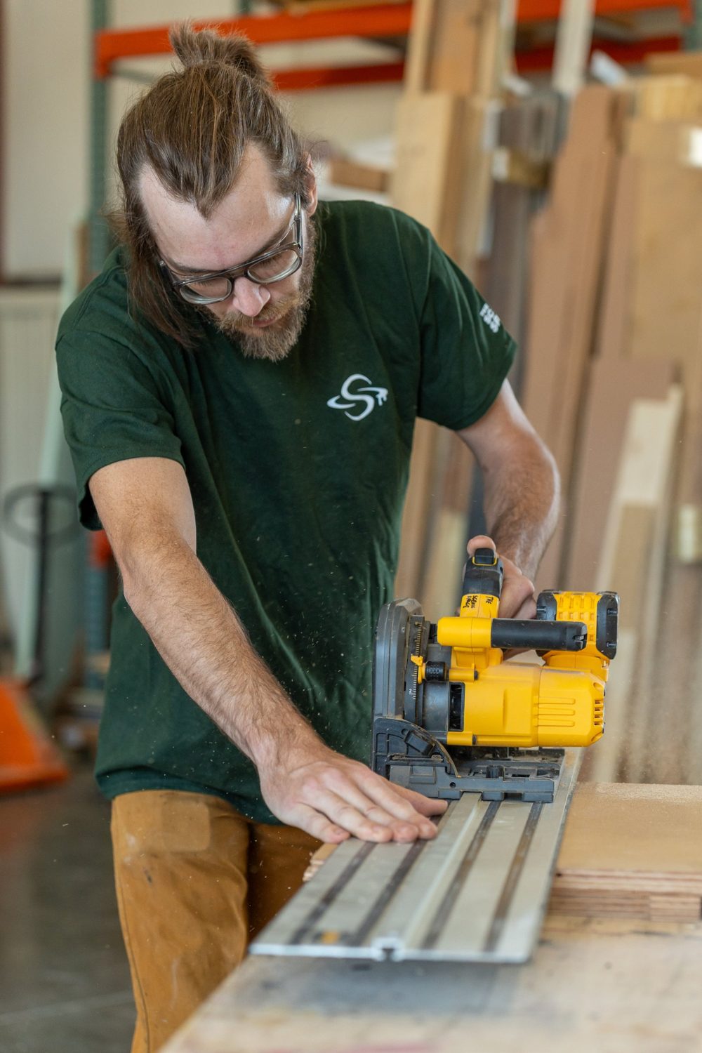 A carpenter cutting a sheet with a track saw
